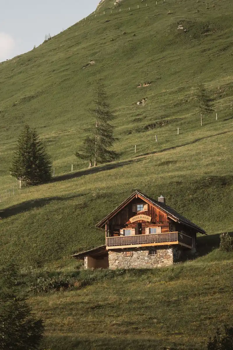 Almhütte am Berghang im Abendlicht